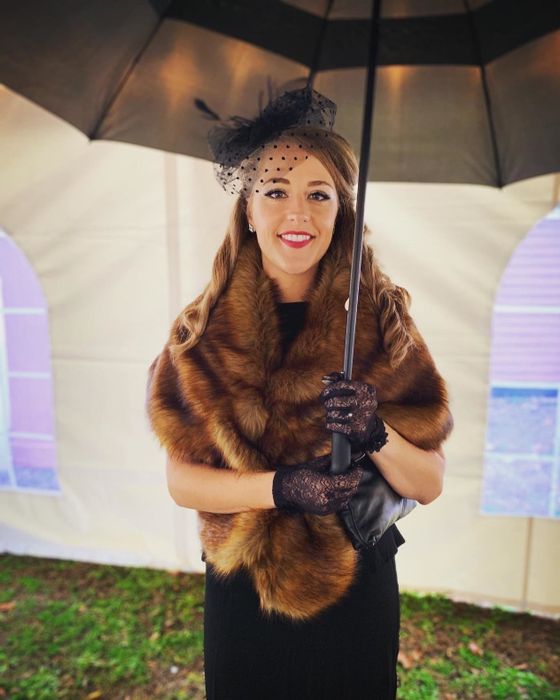 A reviewer wearing a brown faux fur wrap.