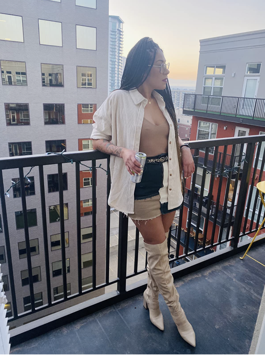 A reviewer shows off the beige version of the top.