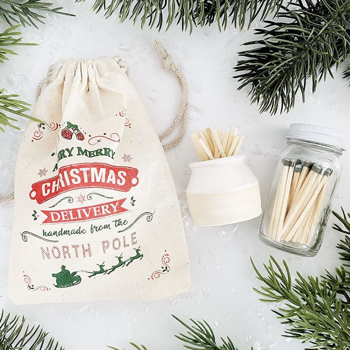 A Christmas-themed drawstring bag, the match striker, and a clear jar of matches