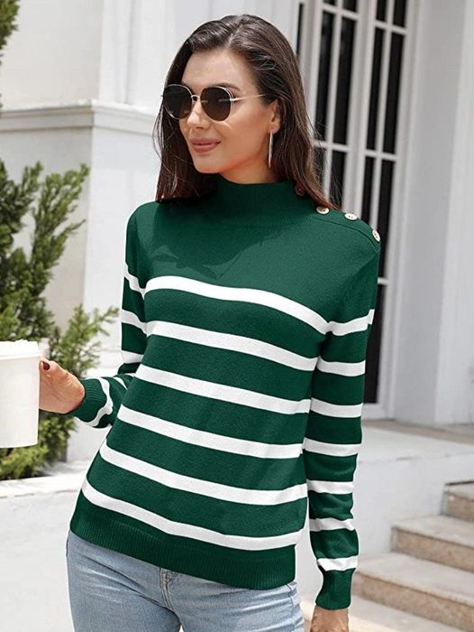 A model dons a dark green and white striped pullover turtleneck sweater, featuring decorative buttons on the shoulders.