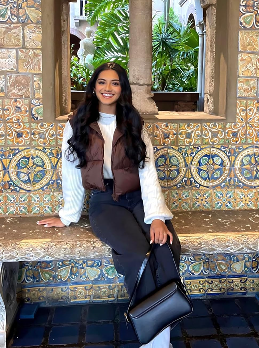 A reviewer posing in a brown puffer vest.