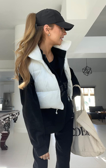 A reviewer posing in a white puffer vest.
