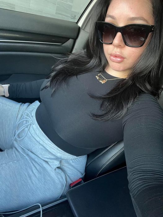 A reviewer wearing a black long-sleeve bodysuit.
