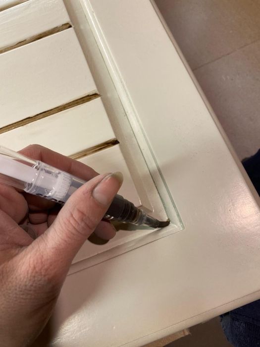 person applying wood finish on furniture using a precision pen