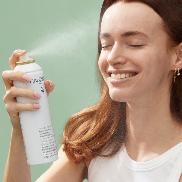 A model gently spraying the facial mist on their face.