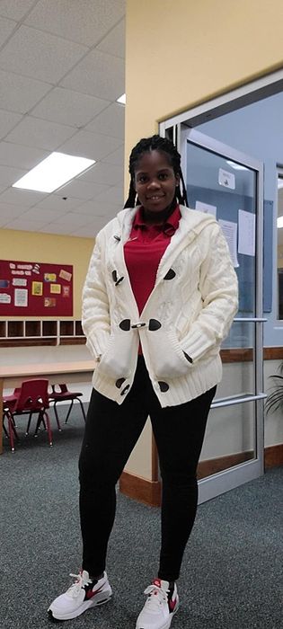 A reviewer shows off the off-white version with brown clasps.