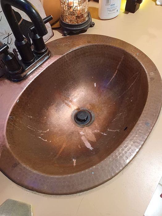 before photo showing a copper sink stained and tarnished from use