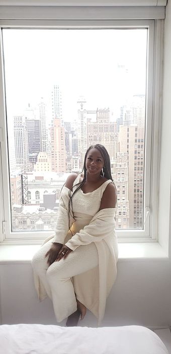 A reviewer wearing a cream-colored fleece lounge set.