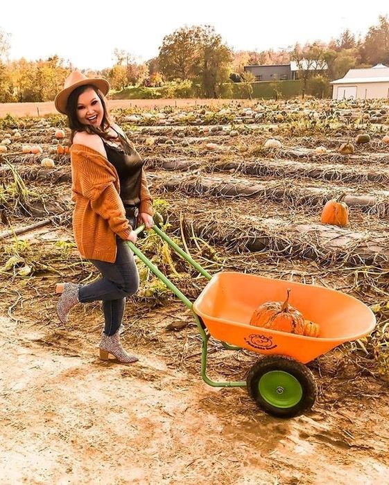 A reviewer models the chunky knit sweater in orange.