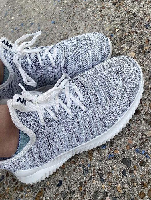 A customer is seen wearing the shoes in grey.