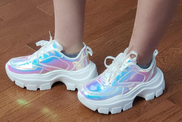 A reviewer wearing holographic chunky platform sneakers
