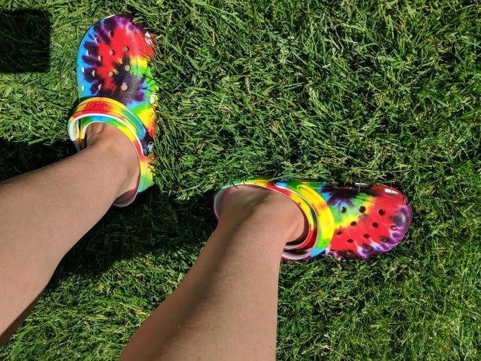 Reviewer sporting tie-dye Crocs outdoors