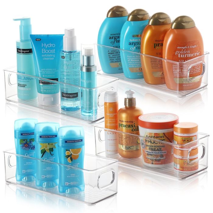 The clear storage containers with handles, each holding a variety of bathroom items in an organized manner.