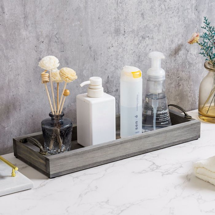 A tray displaying soap and a diffuser on a bathroom vanity.