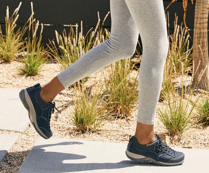 The model is wearing gray waterproof walking sneakers.