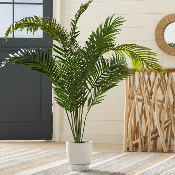 The faux palm plant in its pot, displayed in a living room setting.