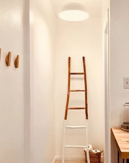 A photo from a reviewer showing the ladder placed next to a basket of toilet paper.