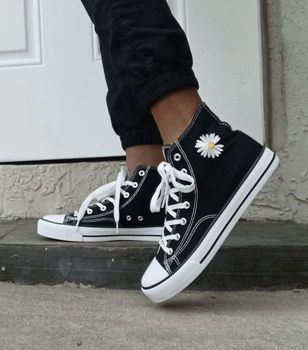 Someone sporting black Converse sneakers
