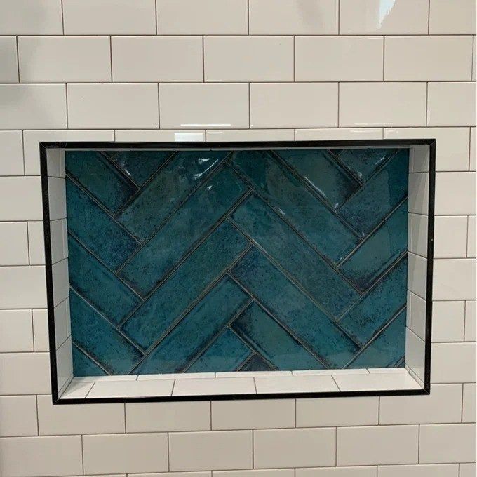 Tiles arranged in a chic diagonal layout within a shower shelf, making a subtle yet striking design statement.