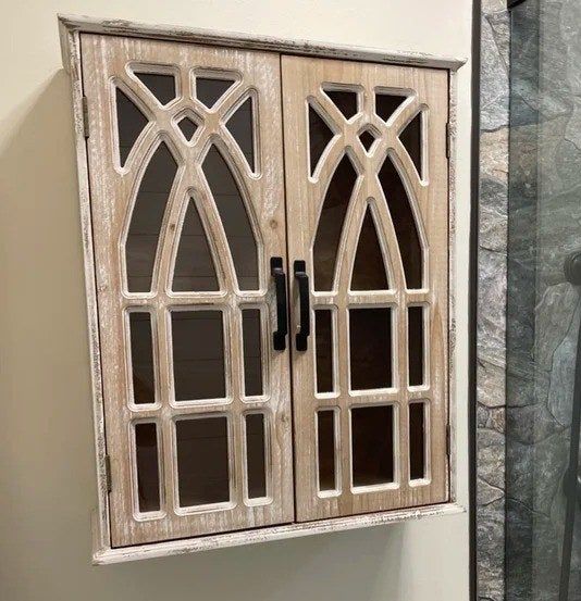 A photo from a reviewer showing the ornate cabinet with detailed doors, installed in a bathroom, making a stylish addition to the space.