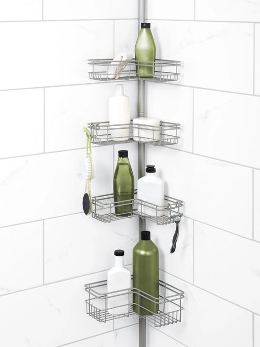 The caddy positioned in the corner of a shower, with four shelves that neatly store bottles and other essentials.