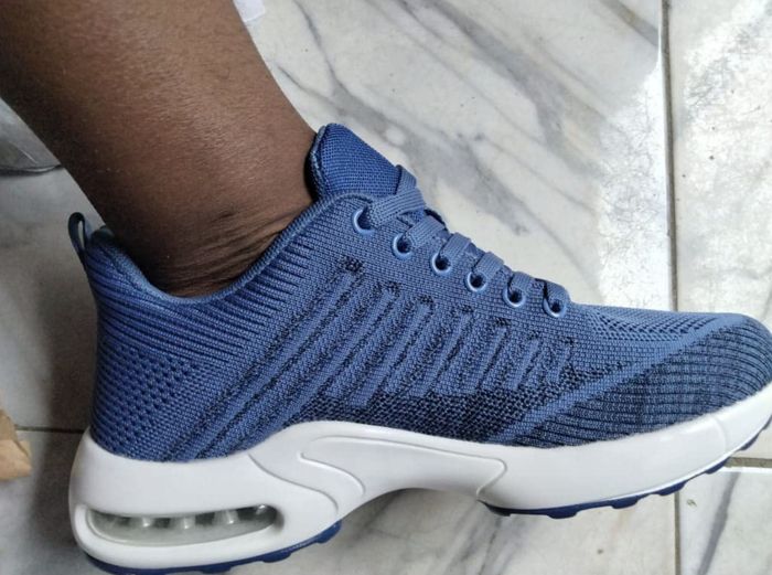 A customer is seen wearing shoes in blue.