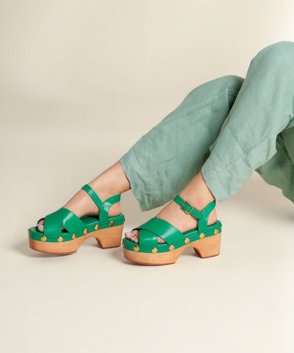 A person sporting green platform clogs