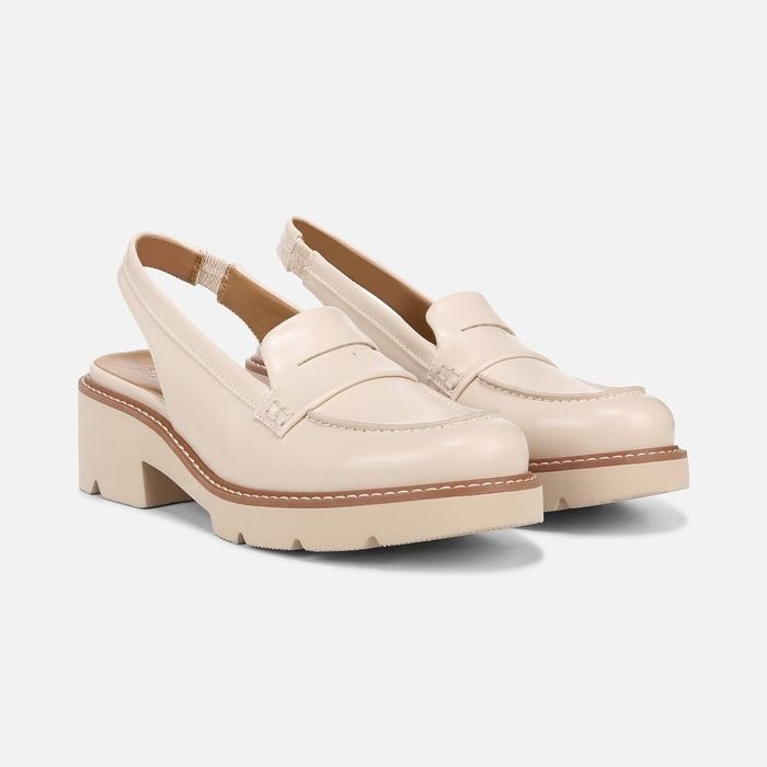A pair of beige loafers with chunky heels and strap detailing