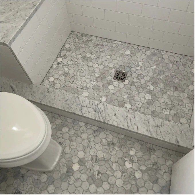 A reviewer’s photo of the honeycomb tiles, beautifully placed on both the bathroom floor and shower floor, showcasing their versatility and style.