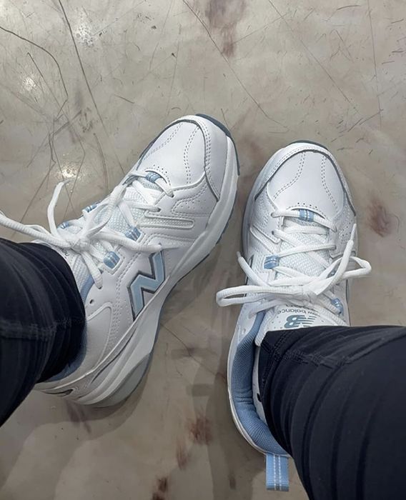 A customer is seen wearing shoes in white and blue.