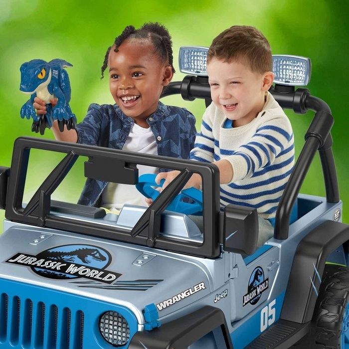 Children happily riding in a Jurassic World-themed Jeep, enjoying the ride together.
