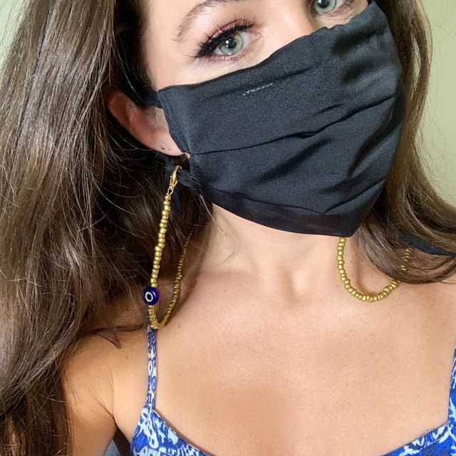 A reviewer showcasing their mask paired with a personalized mask necklace chain.