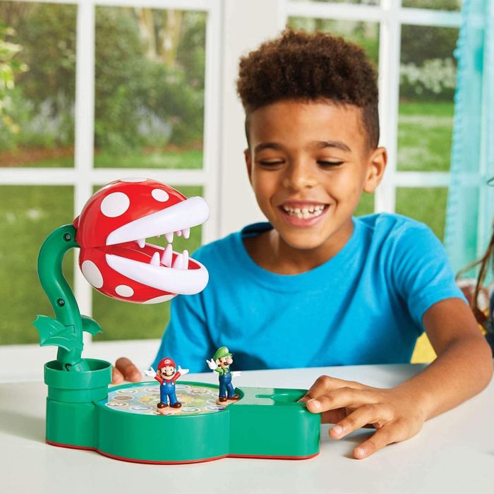 Child enjoying a Mario Brothers tabletop game with a large piranha plant