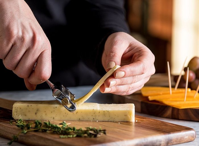 A model demonstrates slicing cheese effortlessly using the slicer.