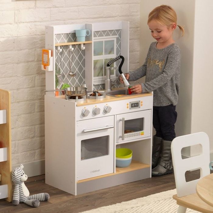 A child happily playing in a kitchen