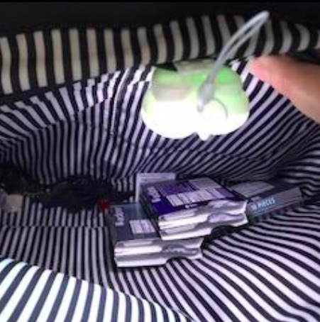 A photo from the reviewer showcasing the inside of their purse with the purse light illuminated.