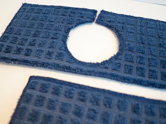 A close-up photo of a navy blue sink drip guard in action.