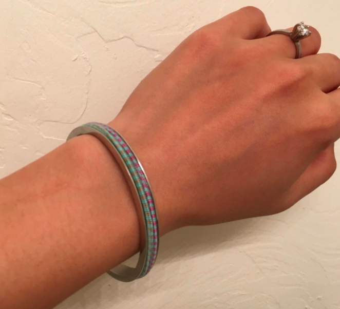 A photo from the reviewer demonstrating the hair tie bracelet worn on a wrist, with two hair ties neatly wrapped around it.