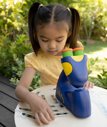 A young one selecting a slide as they stand next to the microscope, eagerly exploring.