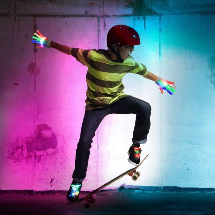 Totally rad child model rocking light-up gloves and shoelaces while riding a skateboard