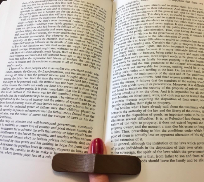 A reviewer using the book page holder to keep their book open while reading.