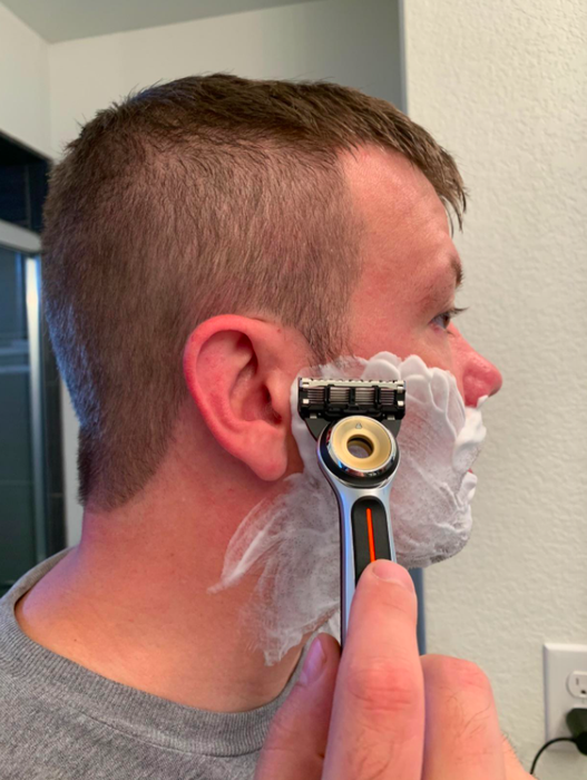 A reviewer using the heated razor for a smooth shave.