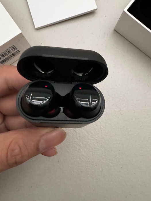 A reviewer showcasing the earbuds in their case