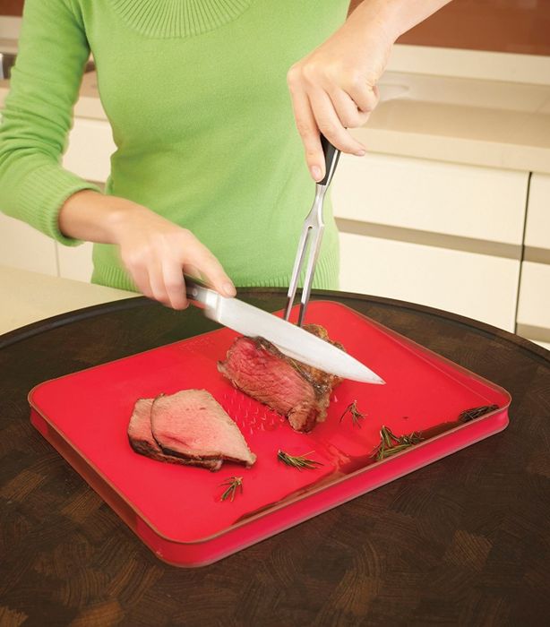 A person demonstrates slicing meat on the cutting board, utilizing the spikes to stabilize the meat.