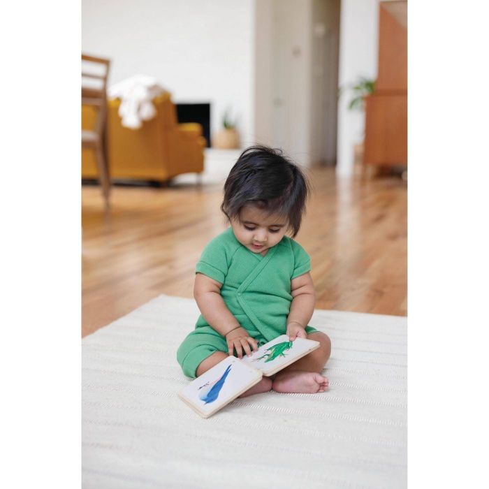 A child engrossed in reading a wooden book.