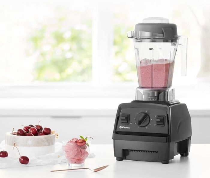 The blender placed on a counter alongside a bowl of cherries