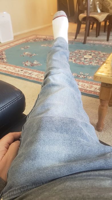 Reviewer POV shot of a leg wearing light blue jeans