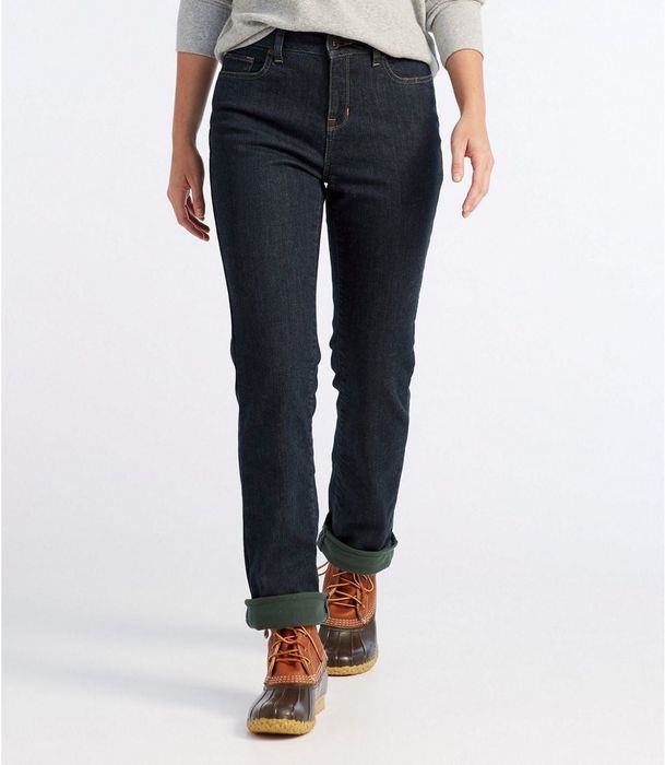 The lower half of a model wearing navy blue cuffed straight jeans paired with L.L.Bean boots