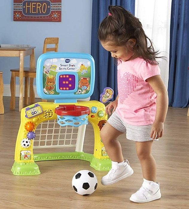 A child having fun playing with the sports center, enjoying the activities it offers.