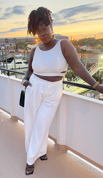 A reviewer sporting the same palazzo pants in white, teamed with a white top